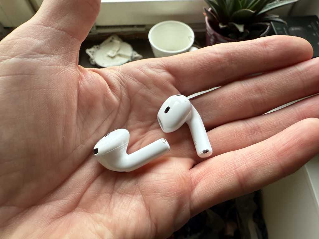 Airpods 4 liggandes i handen