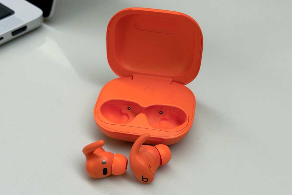 Powerbeats Fit earbuds outside of the case in orange